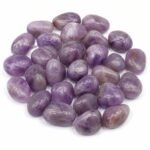 Natural Amethyst Tumble stones with purple shades on white background