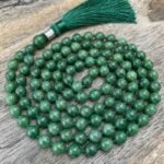 Green jade mala necklace featuring polished round beads and a tassel, traditionally used for meditation and spiritual practices.
