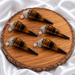 Natural Tiger Eye Dowser pendulum in hand with silver chain on white satin background