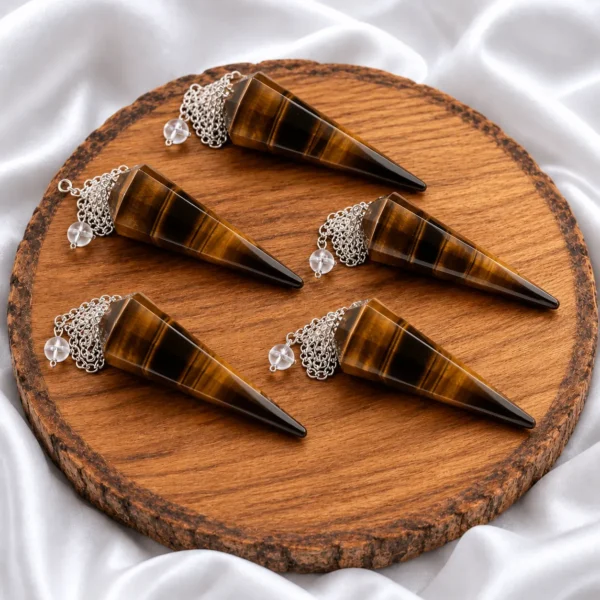 Natural Tiger Eye Dowser pendulum in hand with silver chain on white satin background
