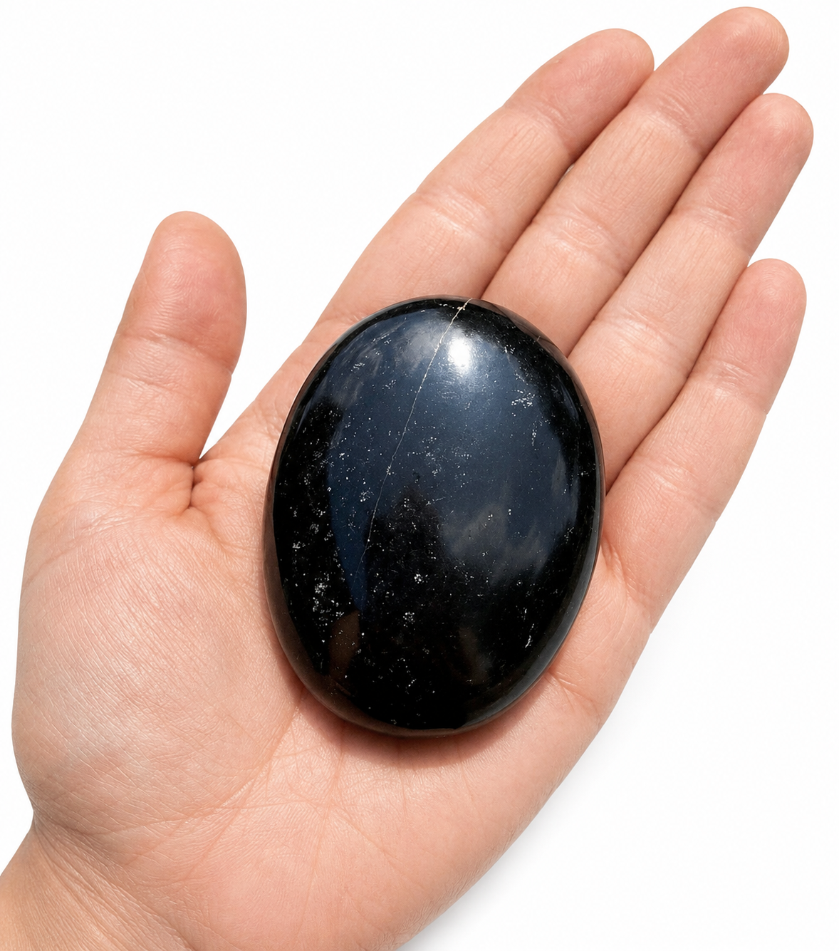 Black Tourmaline Palm Stone / Worry Stone in Hand – Natural Black Crystal Natural Black Tourmaline Palm Stone / Worry Stone held in a human hand on a clean white background.