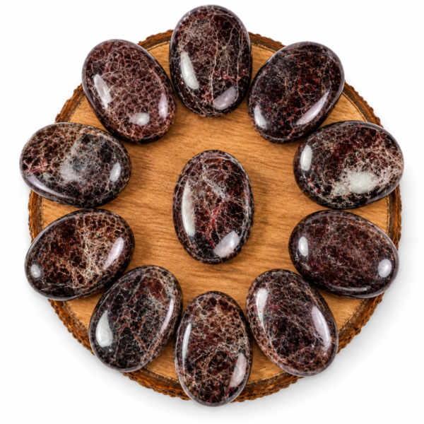 Natural Garnet Palm Stone/Worry Stones arranged in a circle on a wooden display