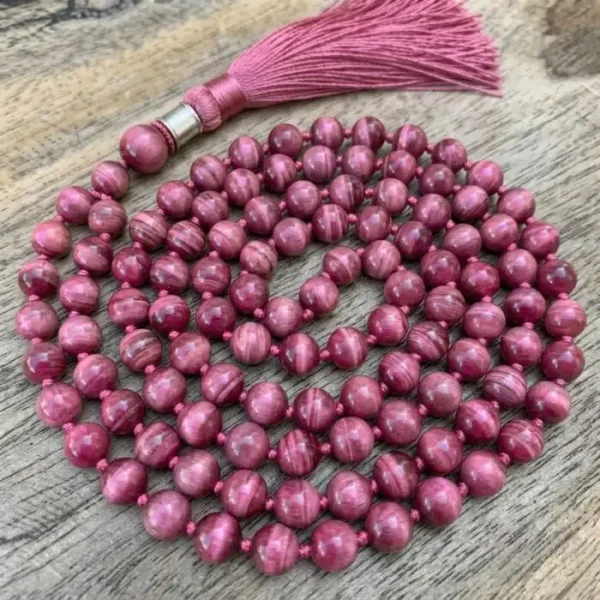 Pink Tiger Eye mala with glossy gemstone beads and a decorative tassel for meditation and spiritual use.