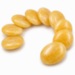Natural Yellow Calcite Palm Stones arranged in a curved formation on a white background