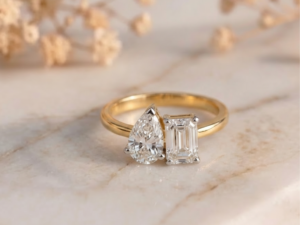 Toi Et Moi emerald and pear lab-grown diamond ring with gold band and elegant two-stone design
