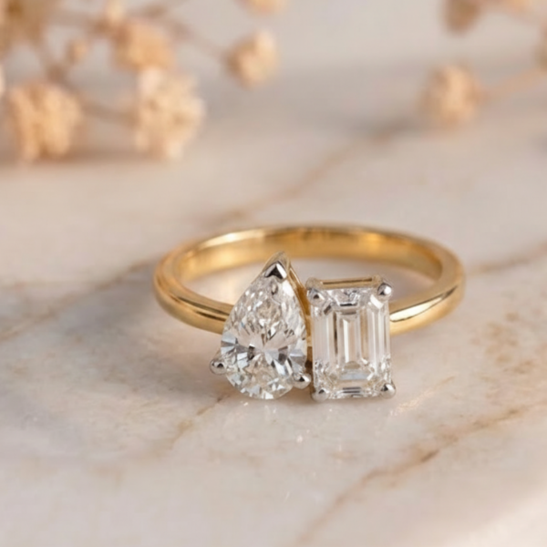 Toi Et Moi emerald and pear lab-grown diamond ring with gold band and elegant two-stone design