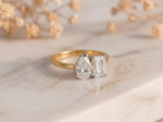 Toi Et Moi emerald and pear lab-grown diamond ring with gold band and elegant two-stone design