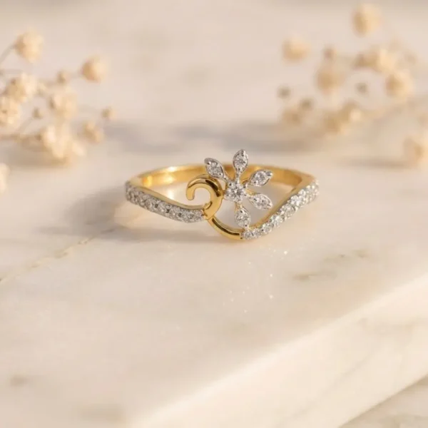Elegant gold ring featuring a diamond floral motif and a pavé-set waving band on marble.