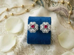 Heart-Centered Ruby Floral Halo Diamond Studs featuring heart-shaped ruby centers surrounded by a floral diamond halo.