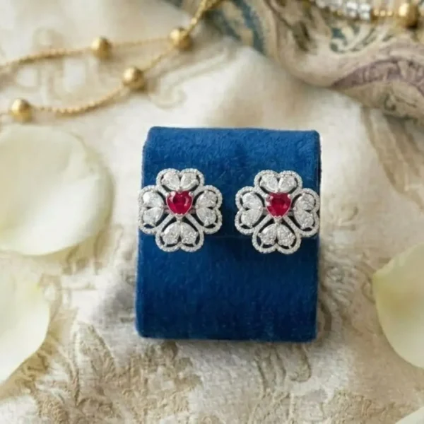 Heart-Centered Ruby Floral Halo Diamond Studs featuring heart-shaped ruby centers surrounded by a floral diamond halo.