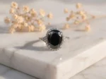 Oval Black Moissanite Halo Ring featuring an oval black moissanite center stone surrounded by a sparkling halo.