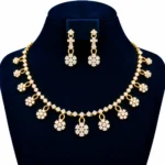 18K gold floral cluster lab grown diamond necklace set with dangling flower motifs and matching drop earrings displayed on navy blue jewellery bust