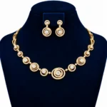 Yellow gold radiant circle lab grown diamond necklace set with concentric diamond motifs and matching circular drop earrings on navy blue display