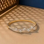 A handcrafted diamond vine bracelet with pear-cut diamonds in a yellow gold setting.