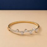 A handcrafted diamond vine bracelet with pear-cut diamonds in a yellow gold setting.