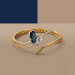A handcrafted diamond vine bracelet featuring blue sapphires and multi-shape diamonds in a white gold setting.