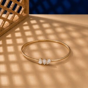 A minimalist diamond vine bracelet with a trio of pear-cut diamonds in yellow gold.