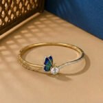 A handcrafted diamond vine bracelet featuring blue sapphires and multi-shape diamonds in a white gold setting.