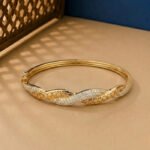 A handcrafted yellow gold diamond vine bracelet featuring a woven lattice pattern and pavé diamonds.