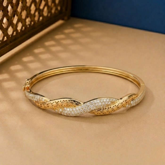 Lattice-Twist-Diamond-Vine-Bracelet A handcrafted yellow gold diamond vine bracelet featuring a woven lattice pattern and pavé diamonds.