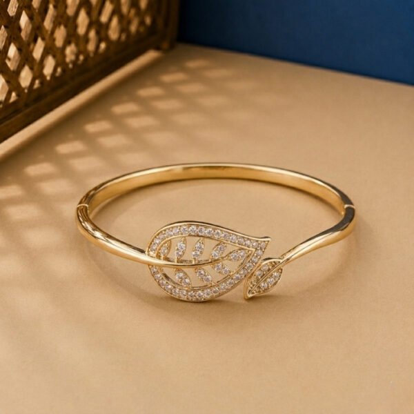 A handcrafted yellow gold diamond vine bracelet with a large pavé-set diamond leaf on a neutral background.