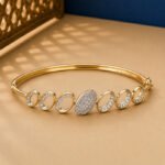 A rose gold diamond vine bracelet featuring a central square halo and diamond-set scrolls on a neutral background.