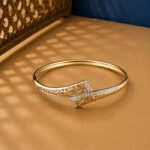 A yellow gold diamond vine bracelet with an oval pavé centerpiece and open-link details on a neutral background.