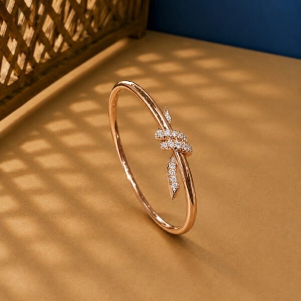 A yellow gold modern abstract diamond vine bracelet featuring a pavé section and a geometric bypass tip on a neutral background.