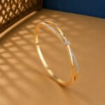 A rose gold diamond vine bracelet featuring a central pavé-set knot on a neutral background.