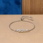 A white gold diamond vine bracelet featuring an asymmetrical marquise-cut diamond leaf branch on an adjustable box chain.
