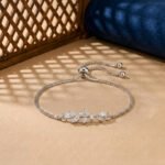 A white gold diamond vine bracelet featuring an asymmetrical marquise-cut diamond leaf branch on an adjustable box chain.