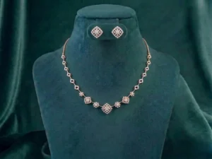 Minimalist geometric jewelry set featuring interlocking diamond clusters on a soft satin fabric.