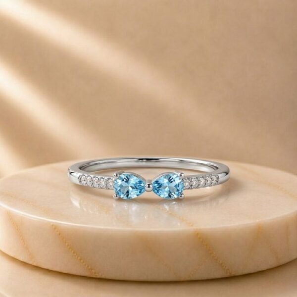 Double Pear Blue Topaz Pavé White Gold Ring featuring two pear-shaped blue topaz gemstones accented with sparkling pavé-set diamonds in elegant white gold.
