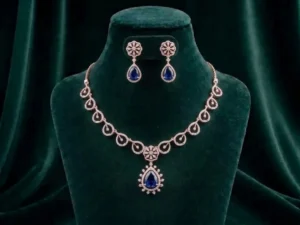 Elegant pear-cut blue sapphire-inspired gemstone necklace surrounded by a diamond halo on a luxury velvet display.