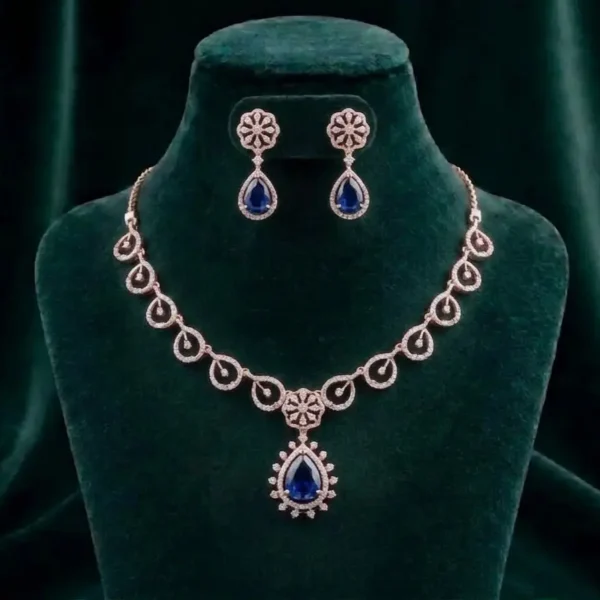 Elegant pear-cut blue sapphire-inspired gemstone necklace surrounded by a diamond halo on a luxury velvet display.