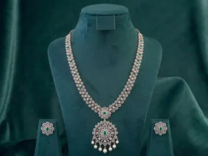 Stunning bridal necklace featuring deep emerald green gemstones and brilliant diamonds on a dark velvet display.