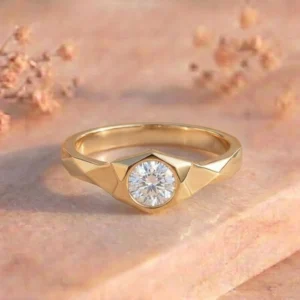 Faceted Shoulder Round Bezel Solitaire Gold Ring featuring a round bezel-set lab-grown diamond with faceted shoulder detailing and a polished gold finish.