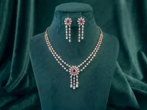 Elegant floral ruby and diamond drop necklace set displayed next to delicate baby's breath.