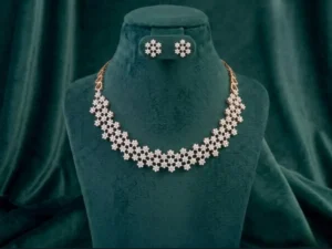 Intricate web-patterned necklace and earring set featuring delicate diamond floral accents on a luxury display.
