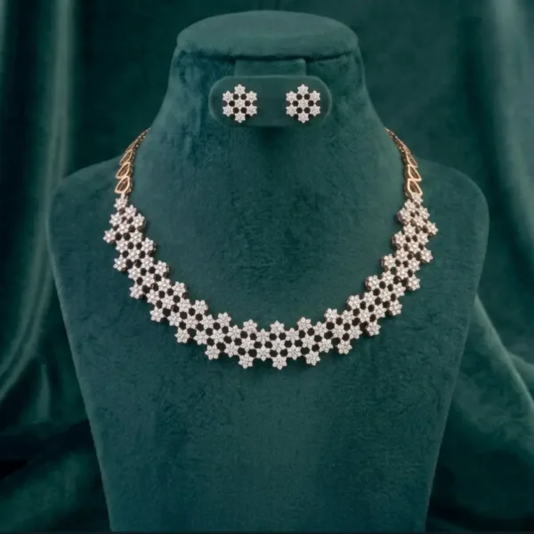 Intricate web-patterned necklace and earring set featuring delicate diamond floral accents on a luxury display.