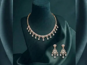 A brilliant diamond necklace and earring set with sharp, V-shaped geometric patterns in a high-polish finish.