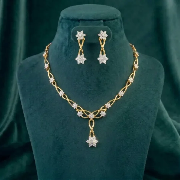 An elegant golden vine necklace and earring set featuring floral diamond clusters on a deep emerald velvet bust.