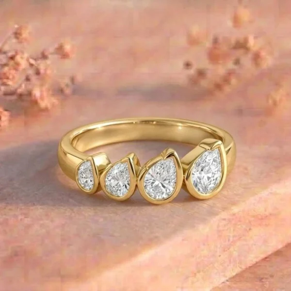 Graduating Pear Bezel Four Stone Yellow Gold Ring featuring four pear-shaped bezel-set lab-grown diamonds in a graceful graduating design with a luxurious yellow gold finish.