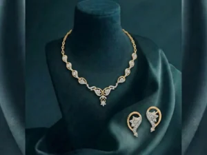 A high-end jewelry set showcasing a delicate leaf-motif necklace and earrings with shimmering pavé diamonds.