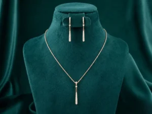 Sleek minimalist bar necklace and matching drop earrings featuring vertical diamond accents on a luxury display.