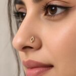 Marquise Aura Lab Grown Diamond Nose Pin worn on a model’s nose, showcasing its delicate yellow gold marquise design and sparkling diamonds.