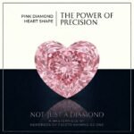 Loose fancy vivid pink heart cut lab grown diamond with brilliant light reflections on a white satin surface.