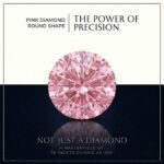 Loose fancy vivid pink round diamond showing ideal facet symmetry and intense sparkle on a crisp white surface.