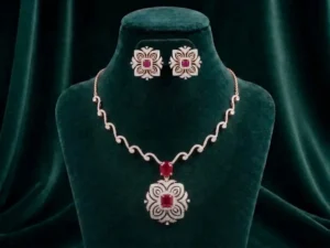 Delicate pink gemstone and diamond necklace set featuring floral blossom motifs on a soft velvet display.
