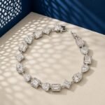 A high-end macro photo of a mixed shape lab diamond tennis bracelet with emerald, pear, and heart-cut stones titled Tennis Bracelet